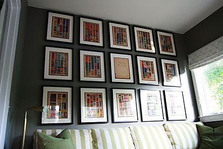 a living room filled with lots of framed pictures on the wall next to a couch