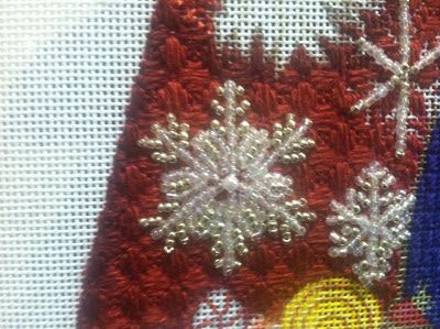 a close up of a piece of cloth with snowflakes on it and an ornament in the middle