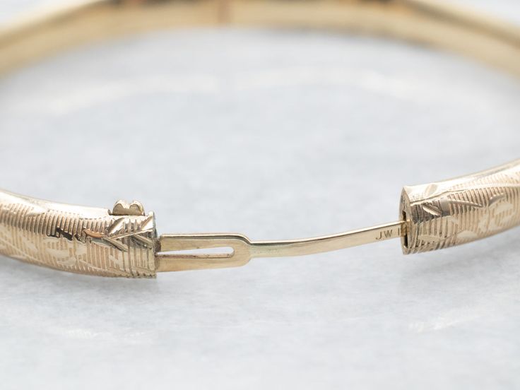 The details on this vintage 14-karat gold bangle are simply stunning! Intricate scrolling botanical designs are engraved in warm yellow gold, covering the entire bracelet. Beautiful on its own or layered with other bracelets this piece is perfect for day or evening wear.Metal: 14K Yellow GoldWidth: 6.3 mmInside Circumference: 6 1/2 InchesMarks: "JW 14K" Stamped on the inside band 14k Gold Bangle Bracelet With Intricate Design, Elegant Engraved 14k Gold Cuff Bracelet, 14k Gold Bangle With Intricate Design For Anniversary, Anniversary 14k Gold Bangle With Intricate Design, Classic Gold Bangle Bracelet With Intricate Design, Classic Gold Bangle With Intricate Design, Elegant Engraved Gold Bangle Bracelet, Classic 14k Gold Bracelet With Intricate Design, 14k Gold Bracelets With Intricate Design For Anniversary