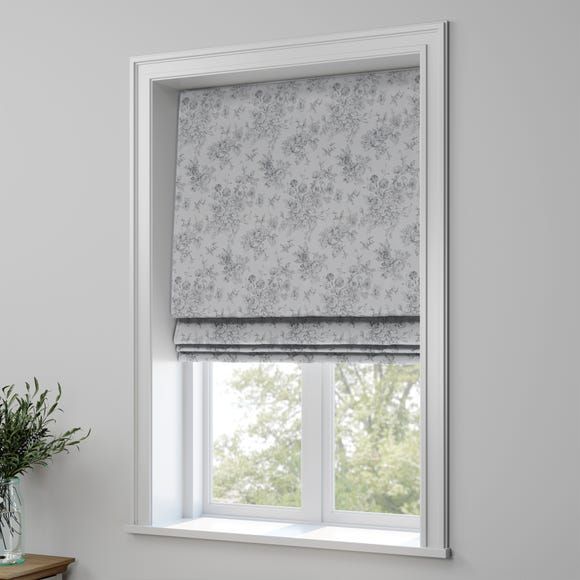 a window with a white roman blind in front of it and a potted plant next to the window