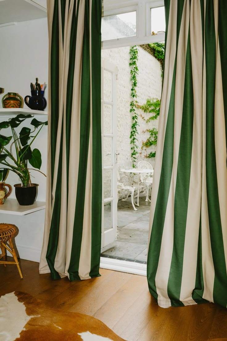 green and white striped curtains in front of a sliding glass door with potted plants