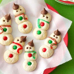 snowmen made out of cookies sitting on top of a red and green table cloth