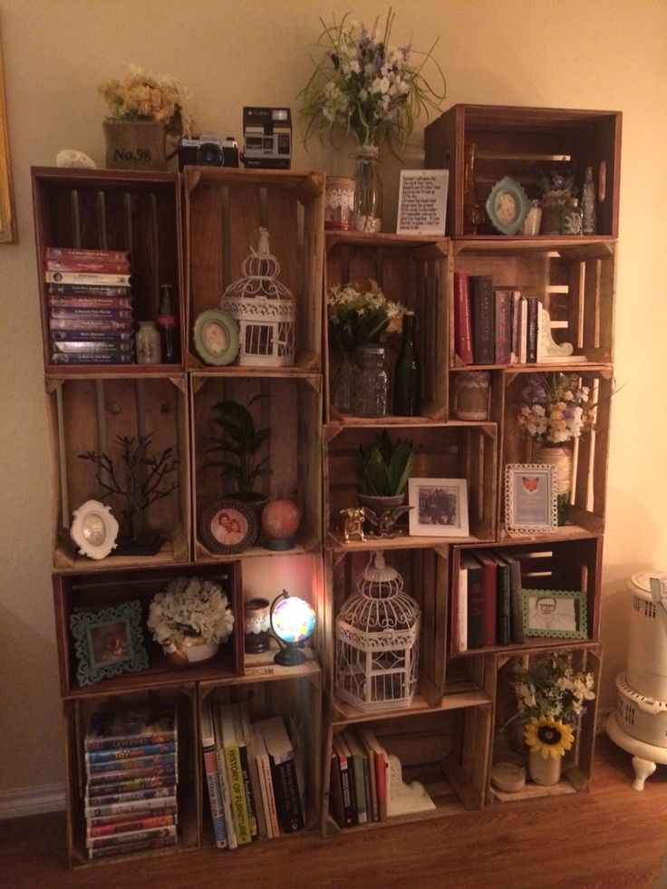 a book shelf filled with lots of books on top of a hard wood floor next to a wall