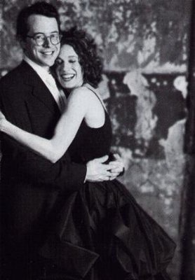 black and white photograph of two people in formal wear hugging each other with their arms around one another