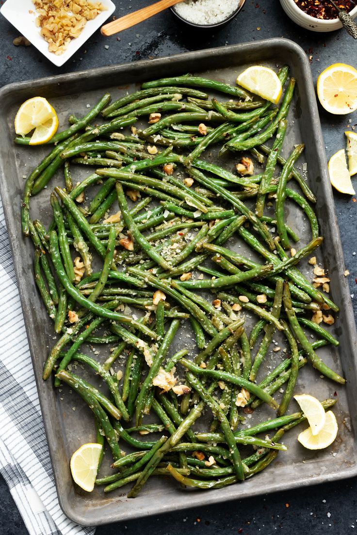 green beans and lemons on a baking sheet