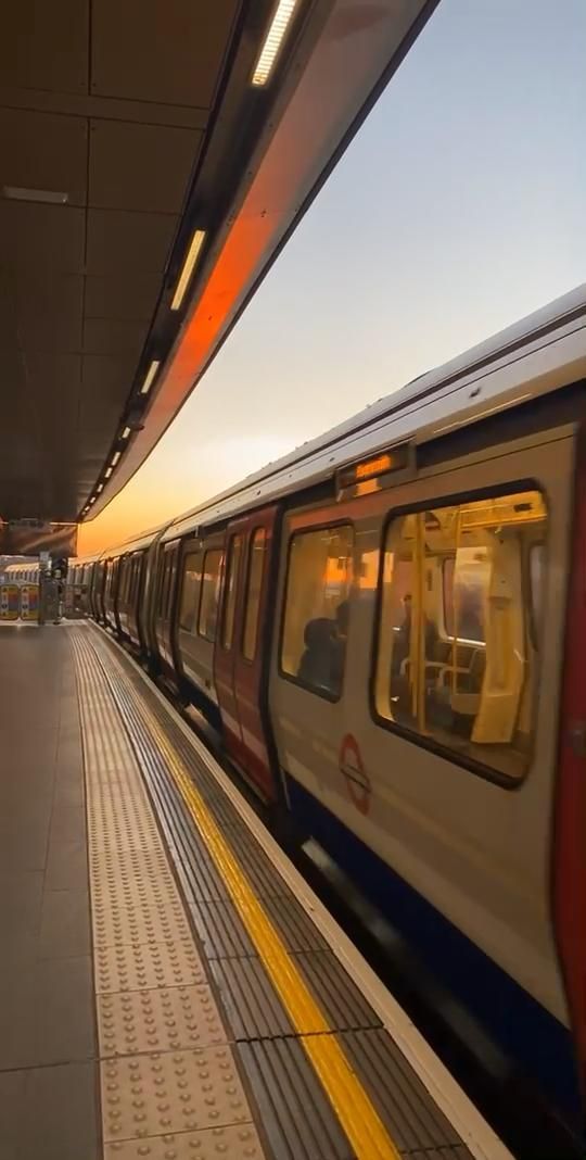 a subway train pulling into the station at sunset