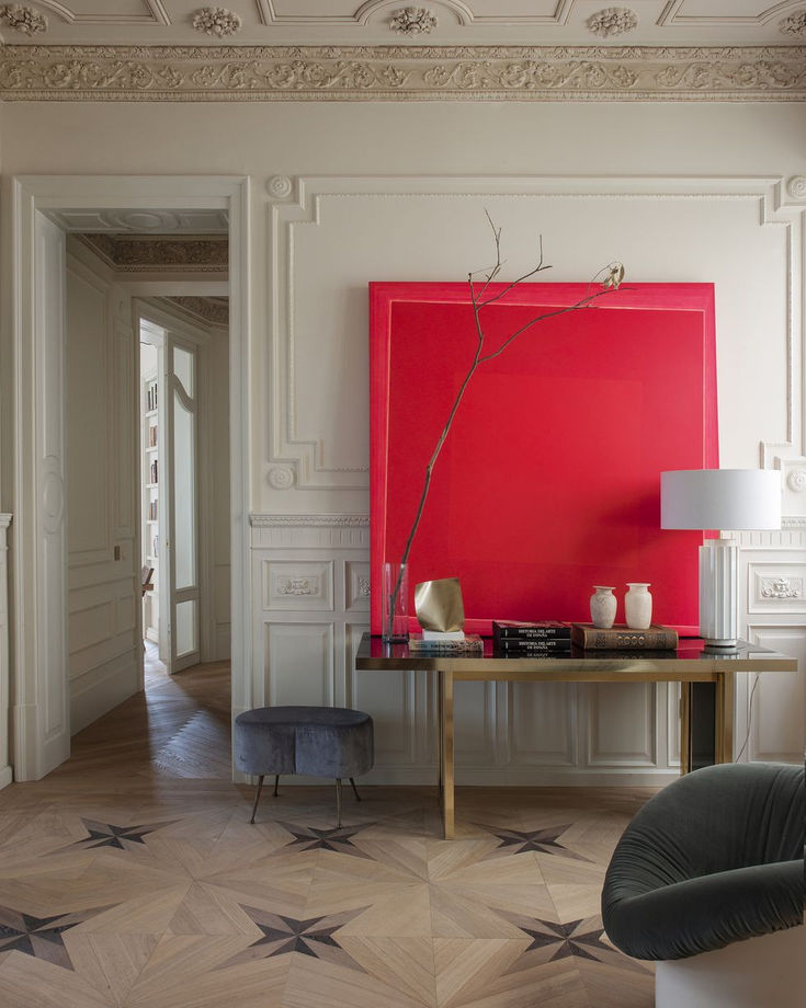 a living room with a large red painting on the wall