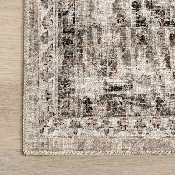 an area rug on a wooden floor with a light brown and beige color scheme,