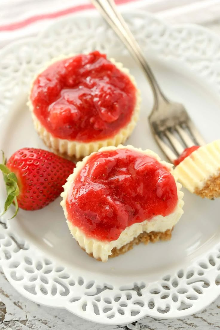 two strawberry cupcakes on a white plate with a fork