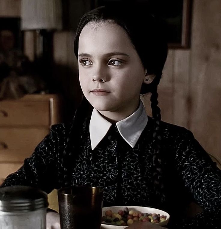 a woman sitting at a table with a bowl of food in front of her