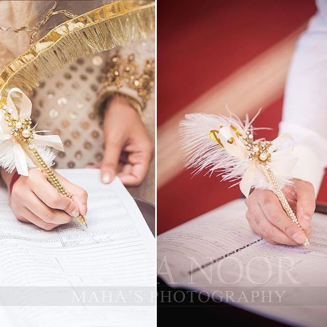 a person holding a pen and writing on paper next to another person's hand