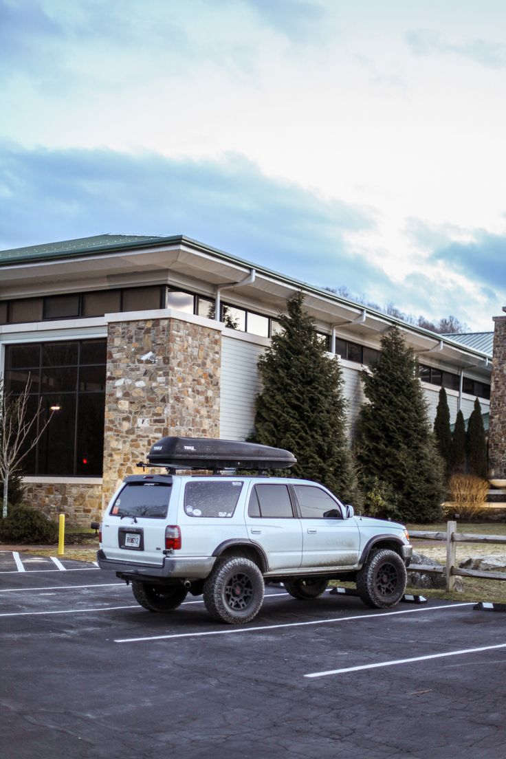 a white suv parked in front of a building