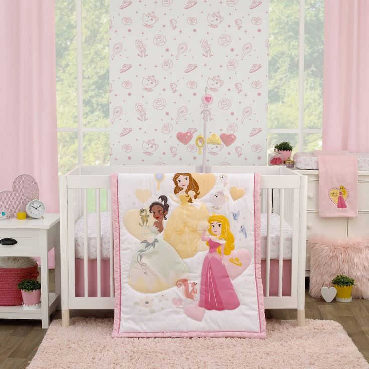 a baby crib bedding set with princesses on it and pink curtains in the background