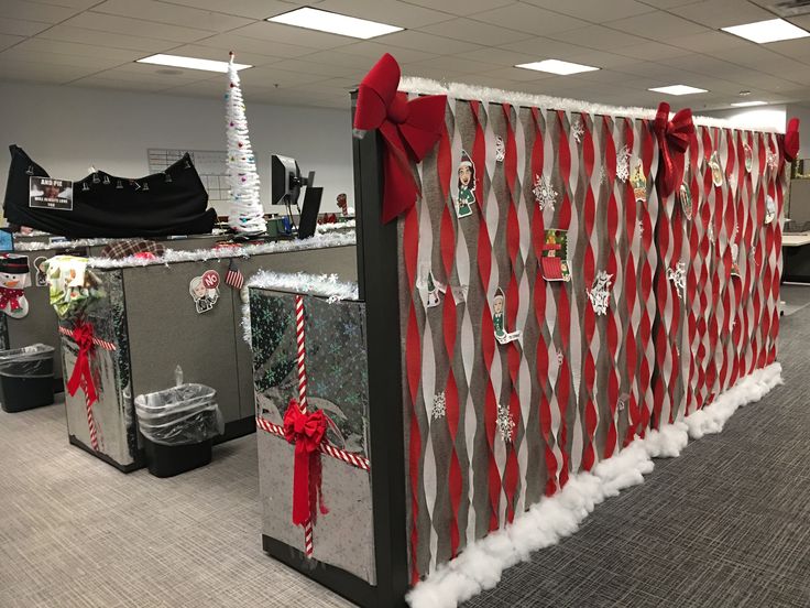 an office cubicle decorated for christmas with red and white decorations on the front wall