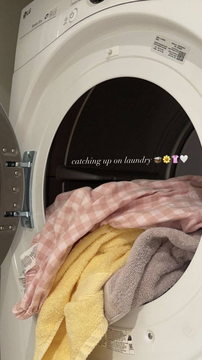 a stack of towels sitting next to a dryer on top of a washing machine