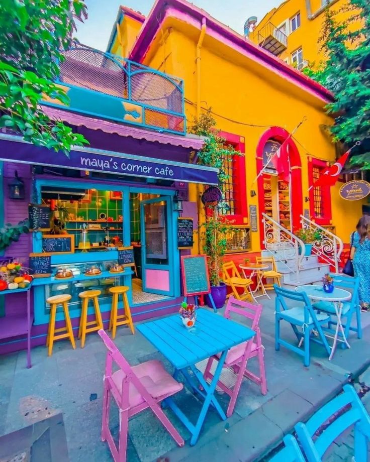 colorful tables and chairs in front of a building with an outdoor cafe on the sidewalk