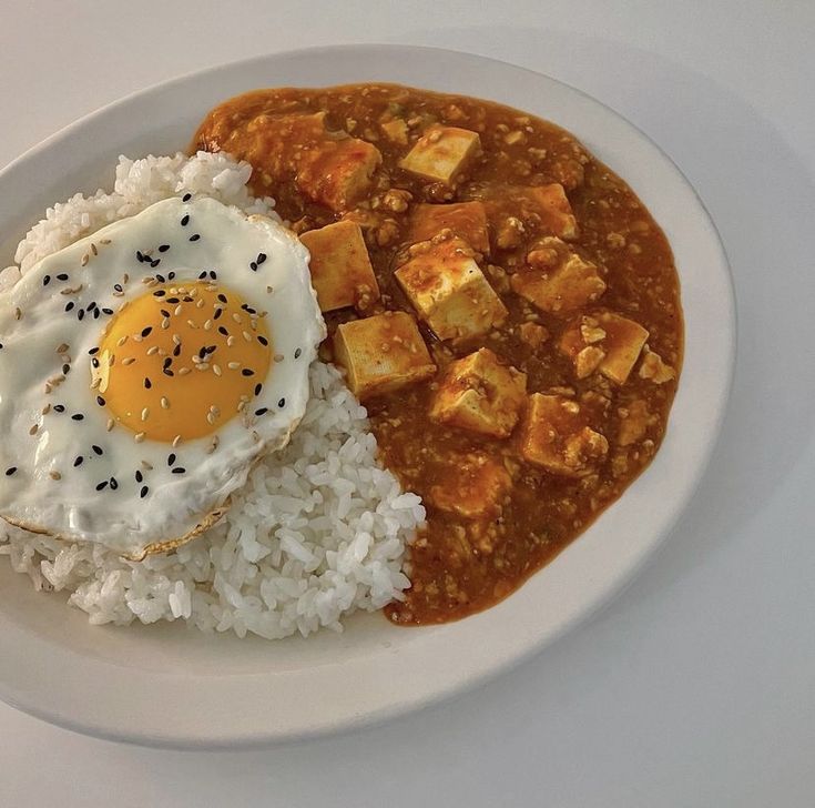 a white plate topped with rice and an egg