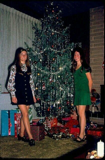 two women standing in front of a christmas tree