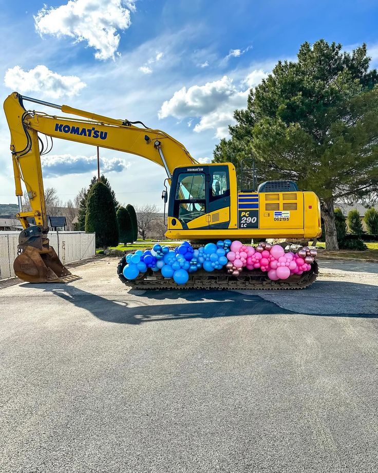 a tractor with balloons attached to it parked on the street