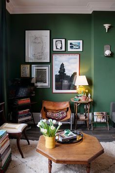 a living room with green walls and pictures on the wall