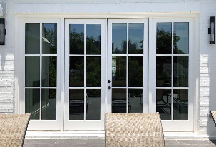 two chairs are sitting on the outside patio with sliding glass doors that lead out to an outdoor dining area