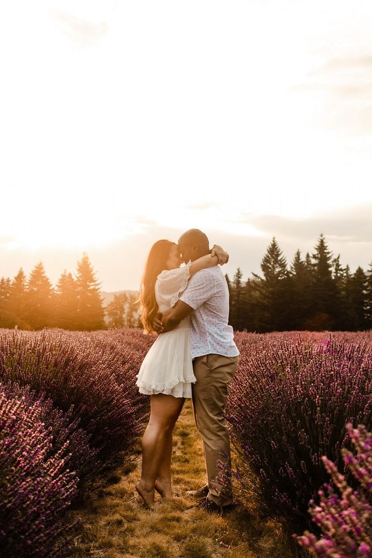 a man and woman embracing in front of lavender fields