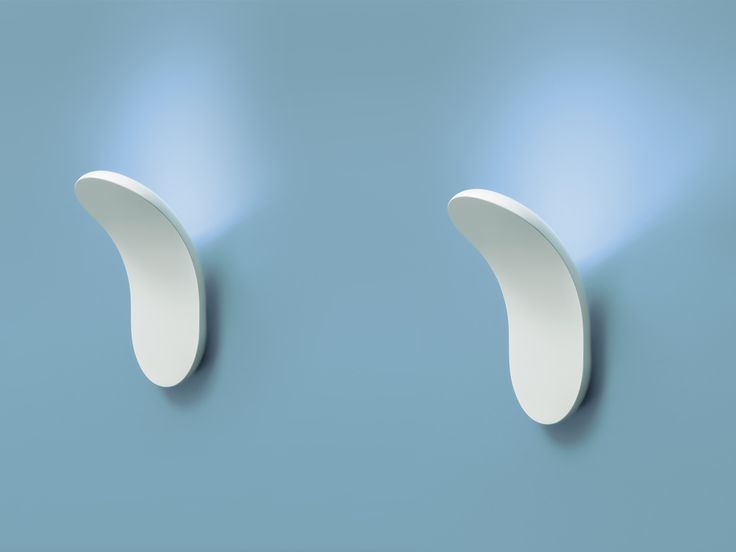 two white curved objects on a blue wall