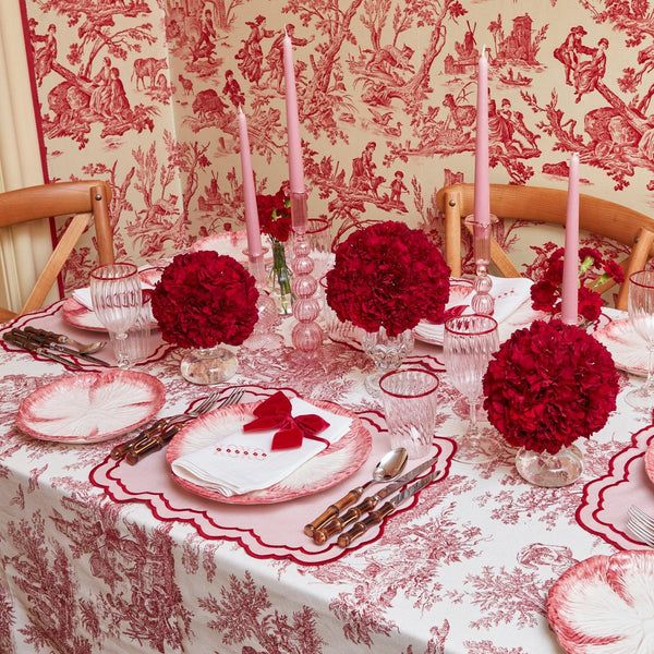 the table is set with pink and red flowers