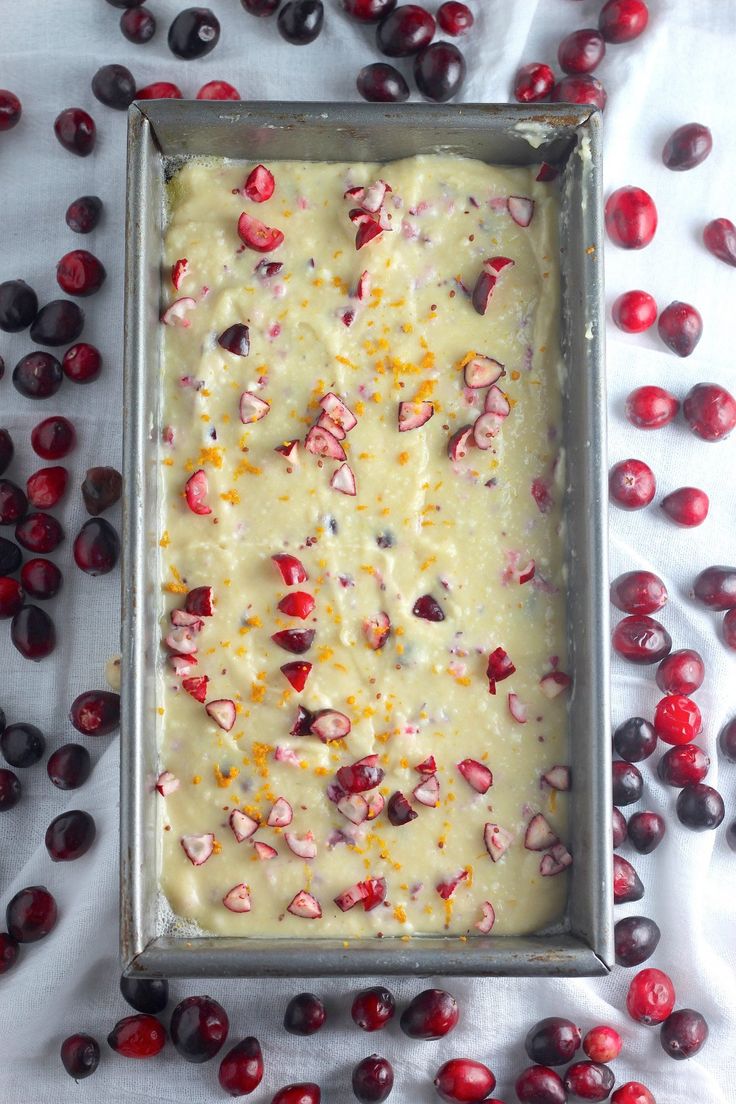 a pan filled with batter surrounded by cranberries