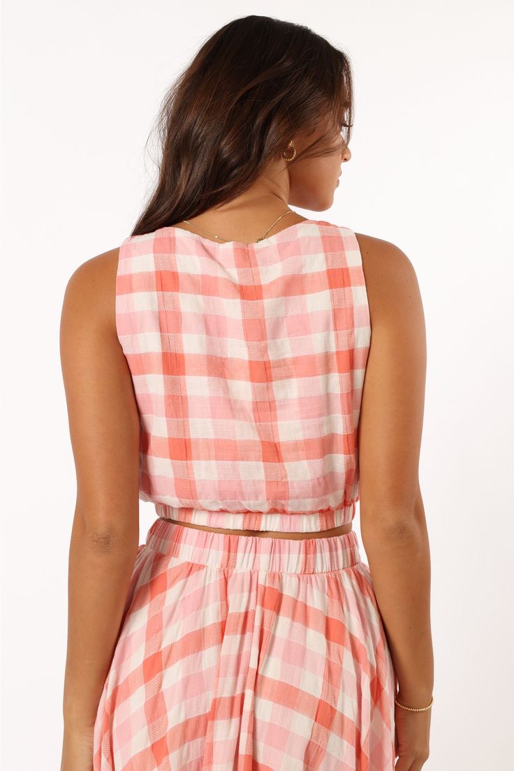 DETAILS   Our Betty Top is the perfect go-to for any sunny day. It features a cropped length, non adjustable straps and an elasticised waistband to keep you stylish and comfortable all day long. With a pink gingham print design to make you stand out from the crowd.   cropped length  round neckline  non adjustable straps  elasticised waistband  gingham print  lined  m aterial - 100% cotton / lining - 100% rayon     SIZING      studio model is 5' 7" and wears a Size S    model stats: bust - 33", w Pink Cropped Top For Vacation, Spring Plaid Cropped Crop Top, Plaid Cropped Top For Spring, Spring Plaid Cropped Top, Plaid Cropped Crop Top For Spring, Gingham Cropped Top For Summer, Spring Cotton Crop Top With Elastic Waistband, Casual Gingham Cotton Crop Top, Casual Gingham Crop Top For Spring