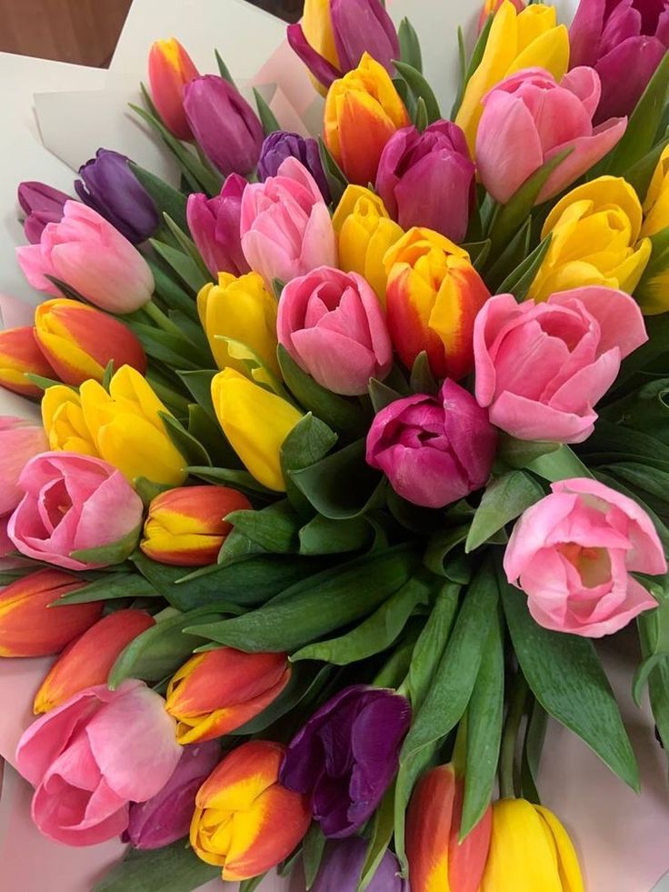 a bouquet of colorful tulips on a table