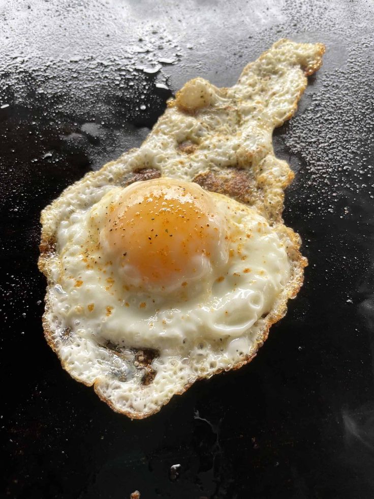 an egg sitting on top of a piece of bread in the middle of a frying pan