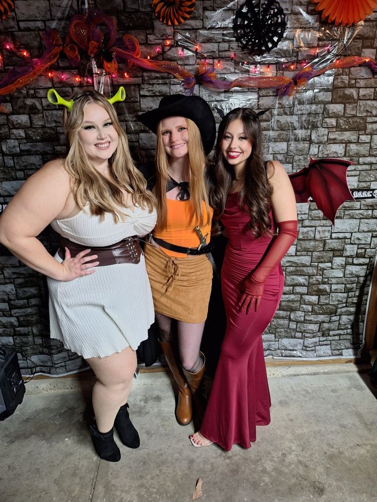 three women dressed up in costumes posing for the camera