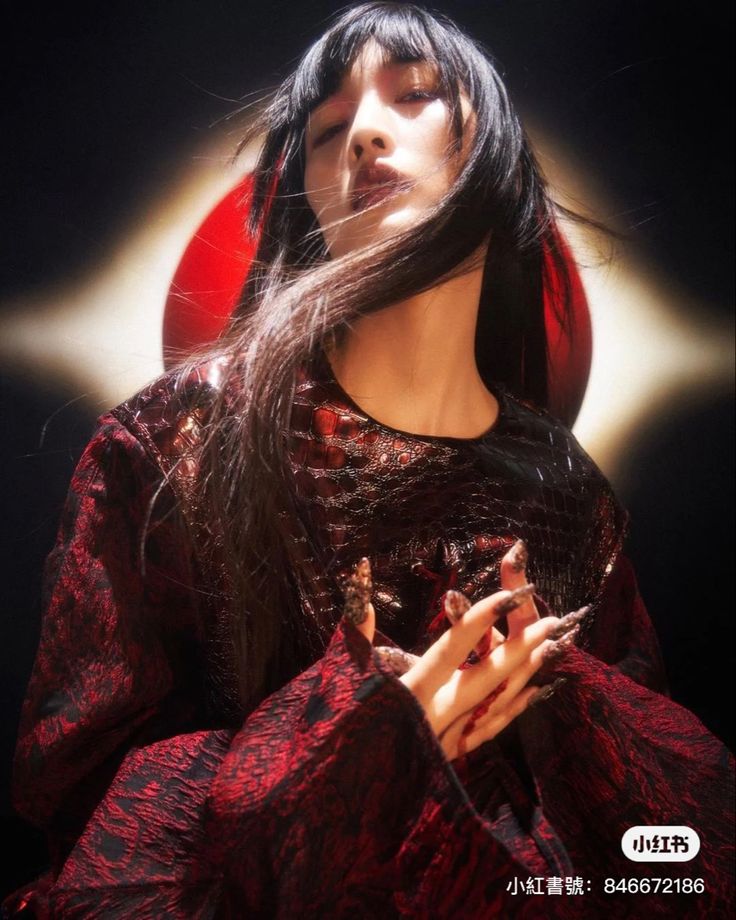 a woman with long black hair wearing a red dress