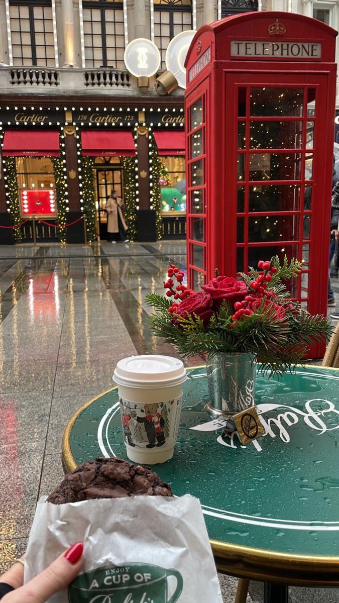 a table with a cup of coffee on it and a phone booth in the background