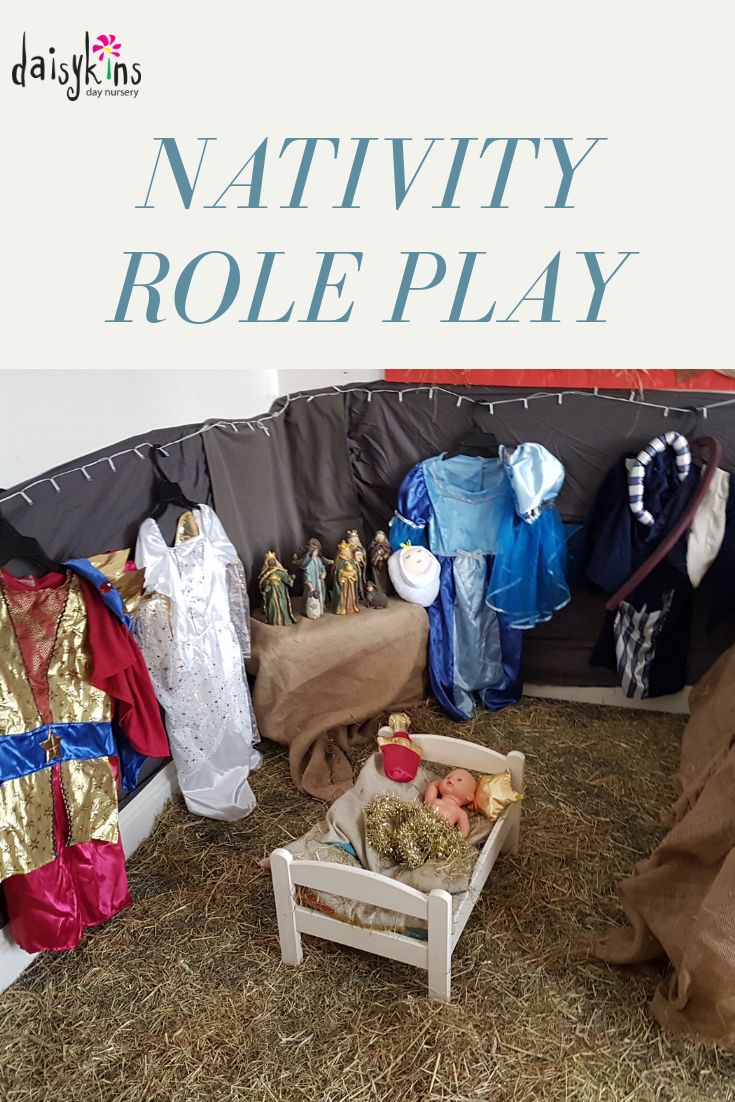 a nativity role play with clothes and toys on the ground in front of it