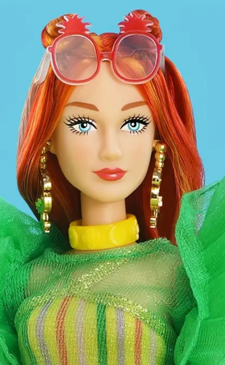 a doll with red hair wearing sunglasses and a green dress on top of a blue background