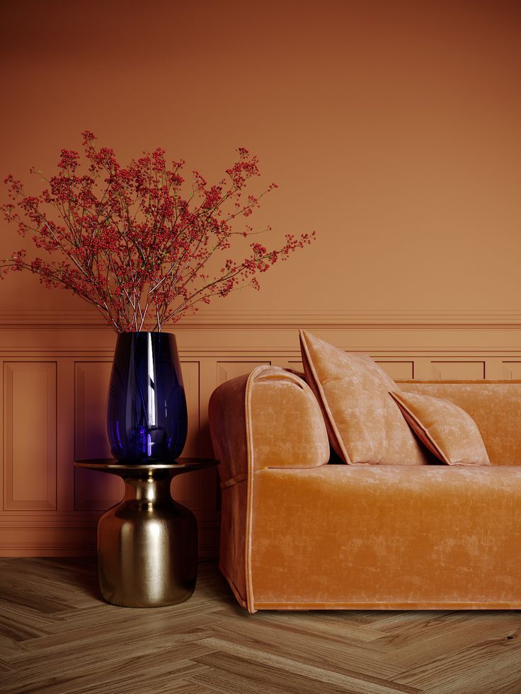 a living room with an orange couch and blue vase