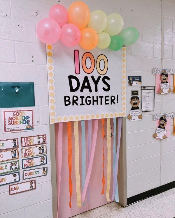 a door decorated with balloons and streamers in the shape of a 100 days brighter sign