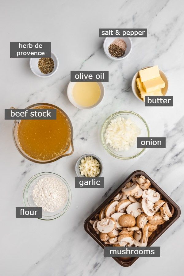 ingredients for mushroom soup laid out on a white marble counter top with words describing the ingredients