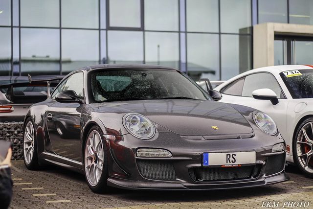 two porsches parked next to each other in front of a building