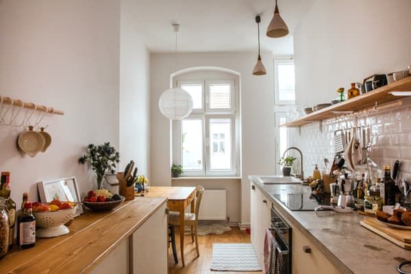 a kitchen filled with lots of counter top space and wooden shelves next to a window