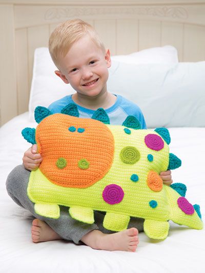 a little boy sitting on top of a bed holding a stuffed animal