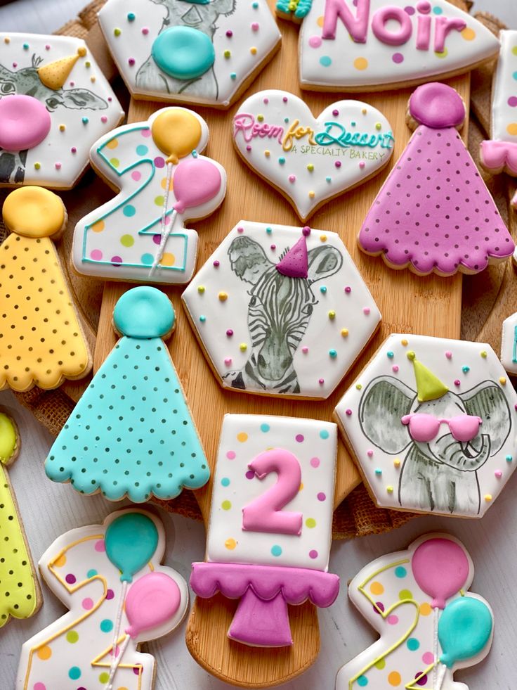 decorated cookies are arranged on a wooden board