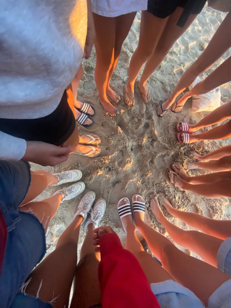 a group of people standing in a circle with their feet on each other's legs