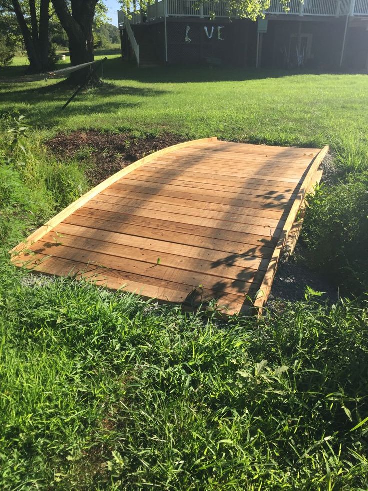 a wooden ramp in the middle of some grass