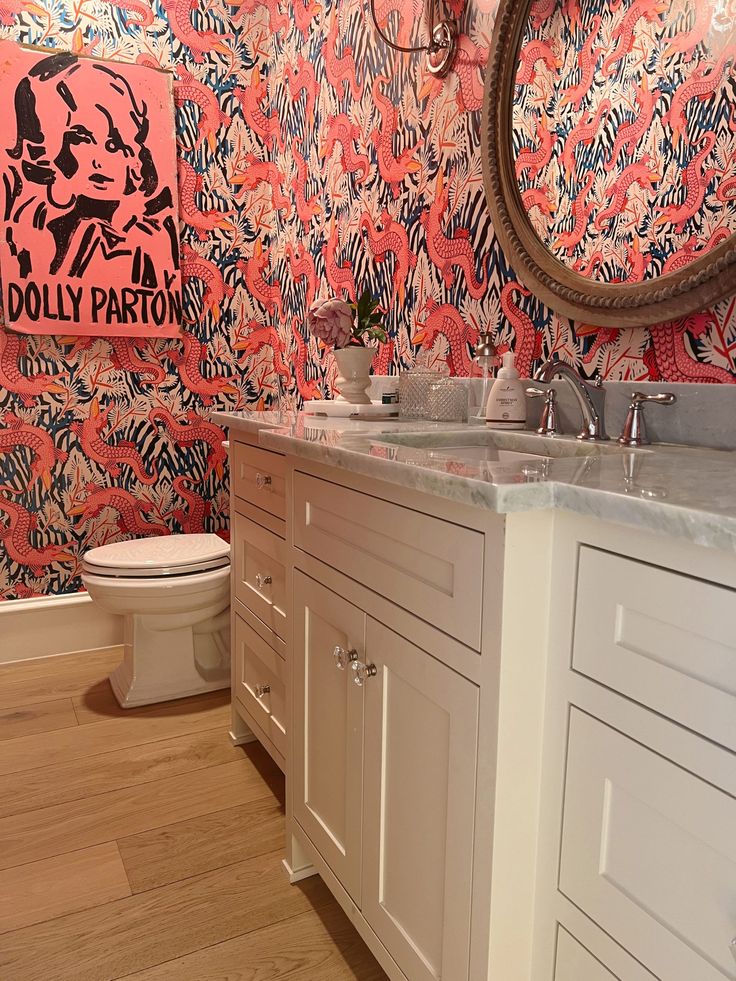 a bathroom with pink and blue wall paper