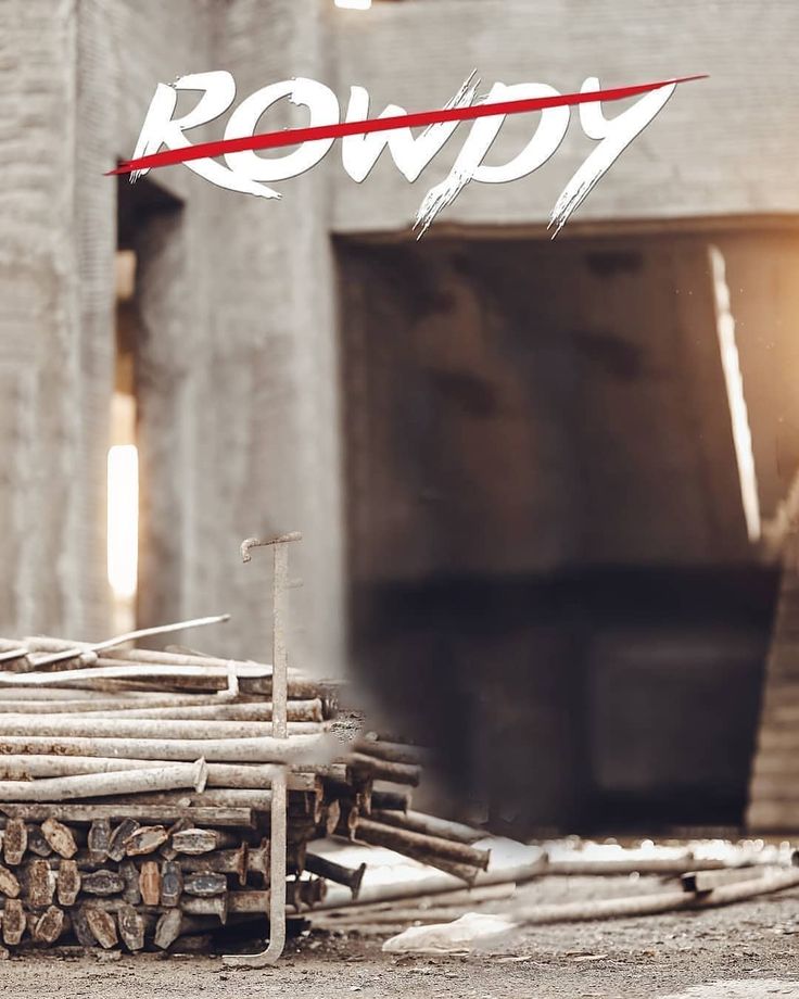 a pile of wood sitting next to a building with the word row written on it