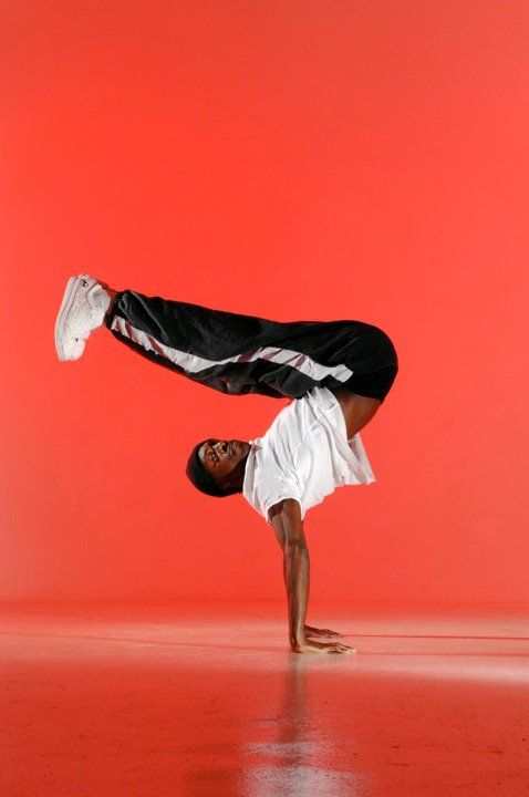 a man doing a handstand on the floor in front of a red background