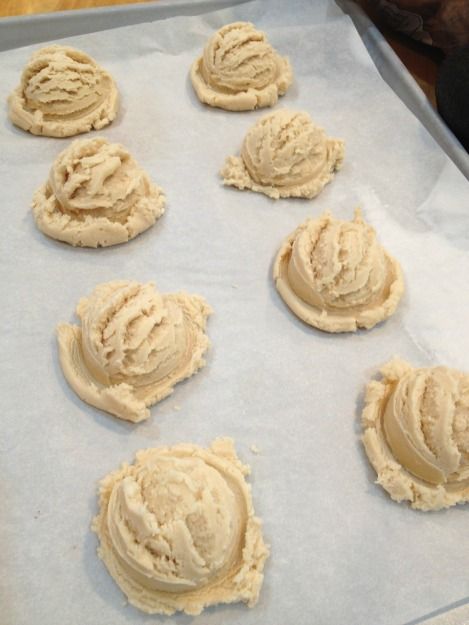 eight cookies are on a baking sheet ready to go into the oven, with icing